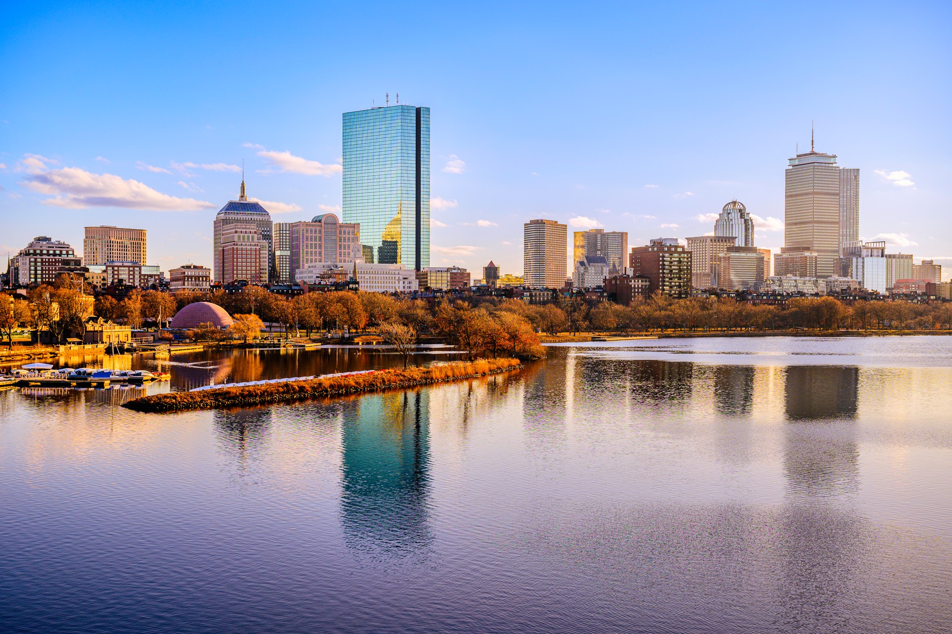 Horizonte de la ciudad de Boston sobre el río Charles en Massachusetts, Estados Unidos. Un tranquilo paisaje fluvial de Back Bay con follaje invernal iluminado dorado en Nueva Inglaterra.